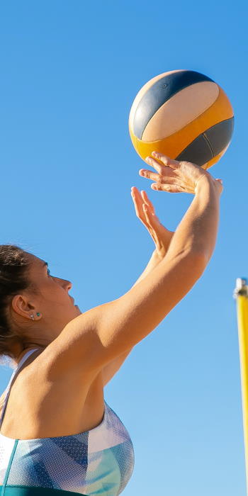 Woman setting a volleyball on the beach